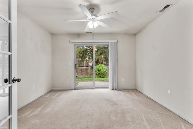 empty room featuring carpet floors, ceiling fan, visible vents, and baseboards