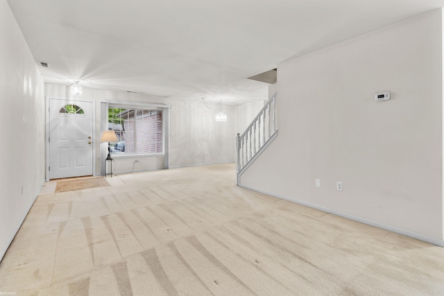 entryway with baseboards, carpet flooring, stairs, and a notable chandelier