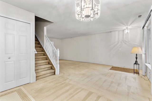interior space featuring carpet flooring, a notable chandelier, and stairway