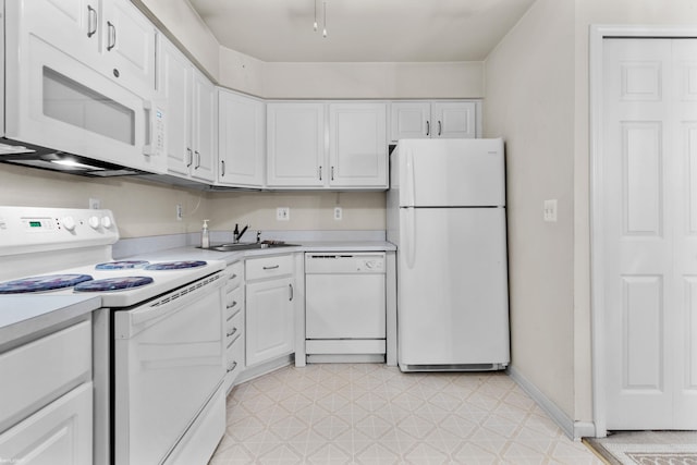 kitchen with white appliances, light countertops, a sink, and light floors
