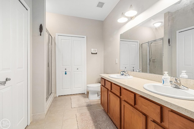 full bath with double vanity, a sink, a stall shower, and tile patterned floors