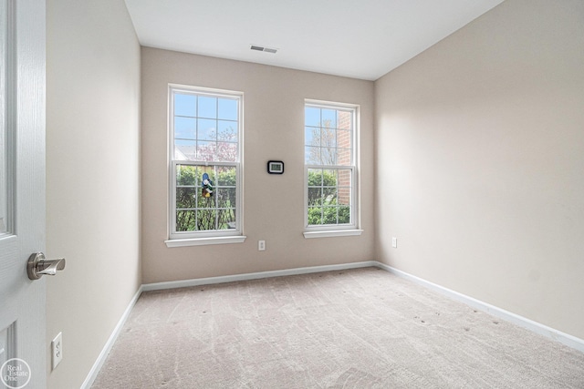 spare room with carpet floors, baseboards, and visible vents