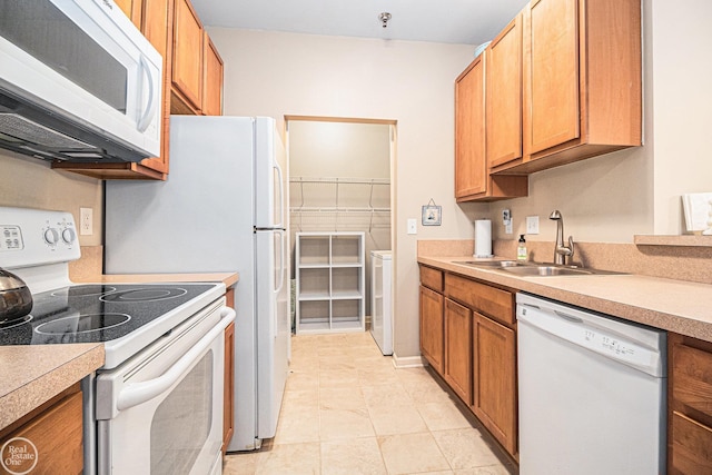 kitchen featuring white appliances, light countertops, brown cabinets, a sink, and light tile patterned floors
