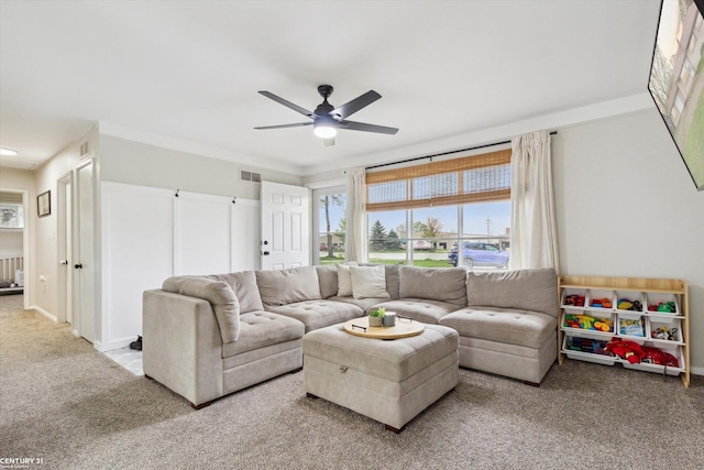 carpeted living area featuring visible vents, a ceiling fan, and plenty of natural light