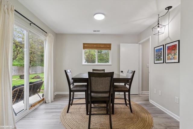 dining area with baseboards and light wood-style flooring