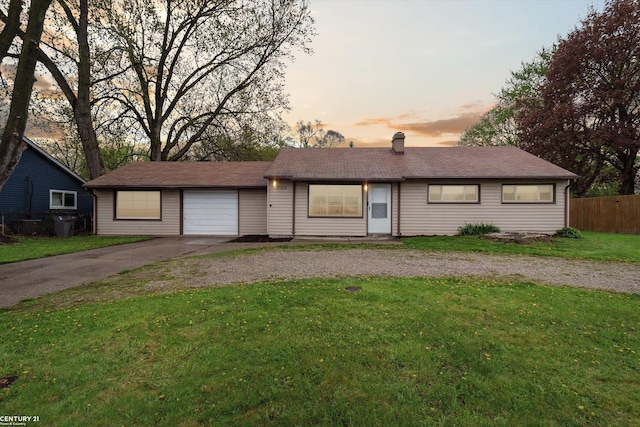 single story home featuring aphalt driveway, fence, a yard, and a chimney
