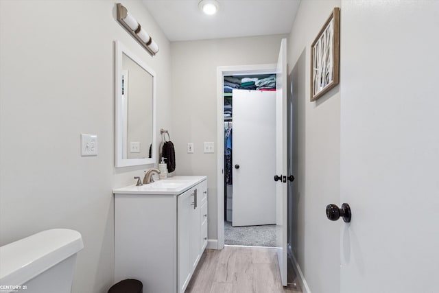 bathroom with vanity, baseboards, and toilet