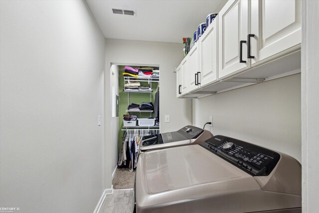laundry room with visible vents, wood finished floors, baseboards, cabinet space, and independent washer and dryer