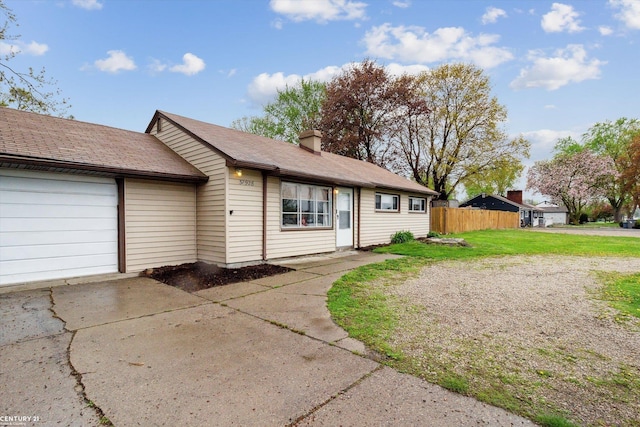 single story home featuring a front lawn, fence, a chimney, concrete driveway, and an attached garage