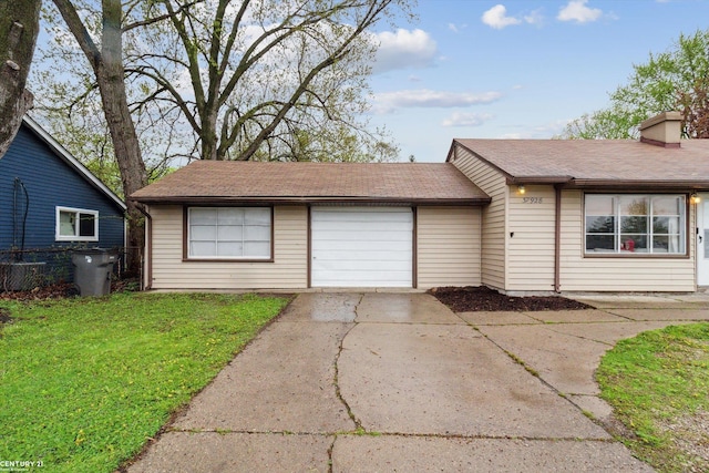 ranch-style house featuring an attached garage, fence, driveway, and a front yard