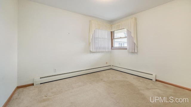 carpeted spare room with baseboards and a baseboard heating unit