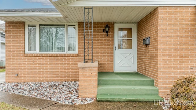 doorway to property with brick siding
