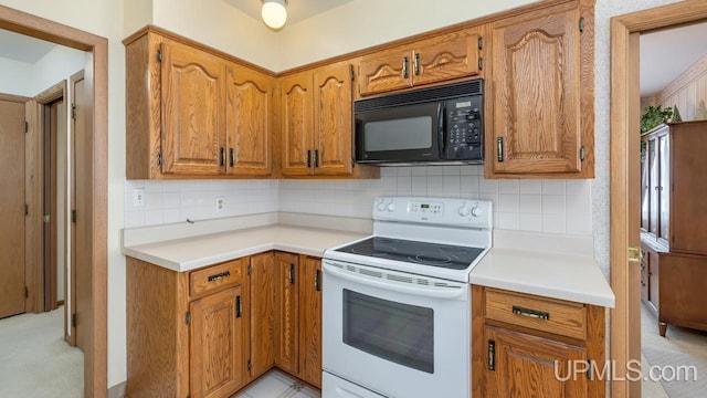 kitchen featuring brown cabinetry, electric stove, black microwave, and tasteful backsplash