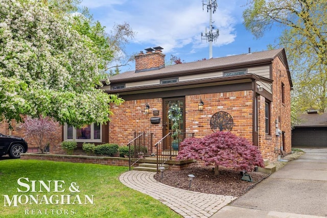 view of front of home with brick siding, a garage, a chimney, and a front yard