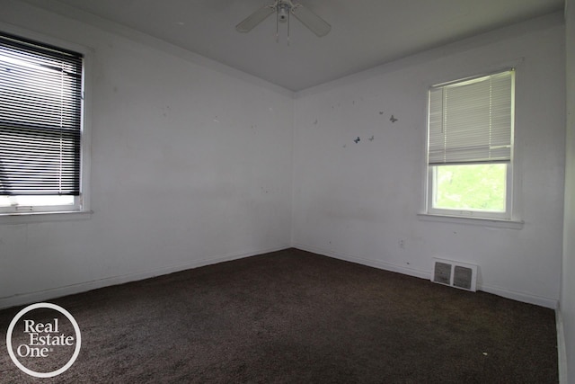 carpeted empty room with baseboards, ceiling fan, and visible vents