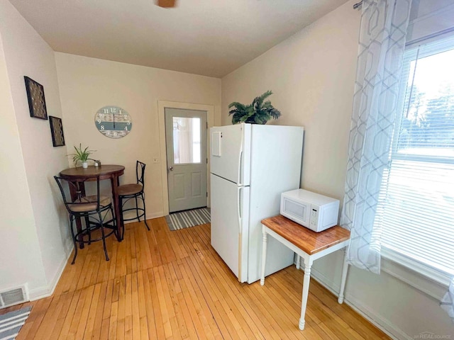 kitchen featuring visible vents, light wood finished floors, and white appliances