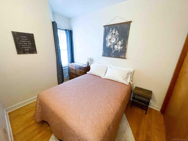 bedroom with baseboards and wood finished floors