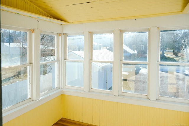 unfurnished sunroom with wooden ceiling and wood walls