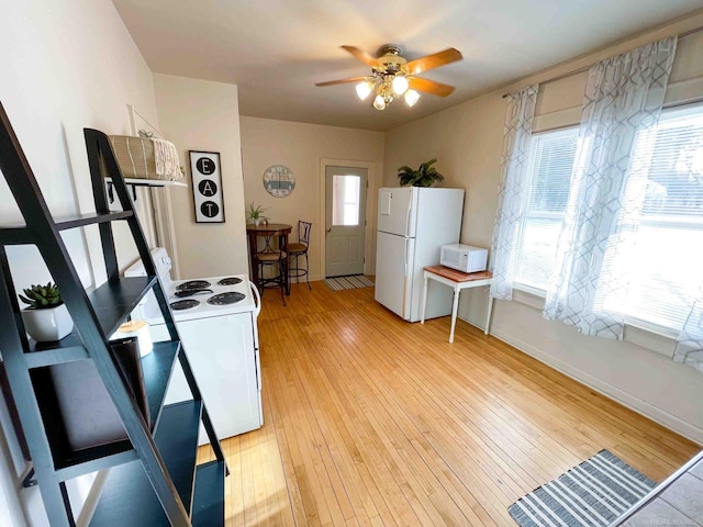 kitchen with white appliances, ceiling fan, baseboards, and light wood-style floors