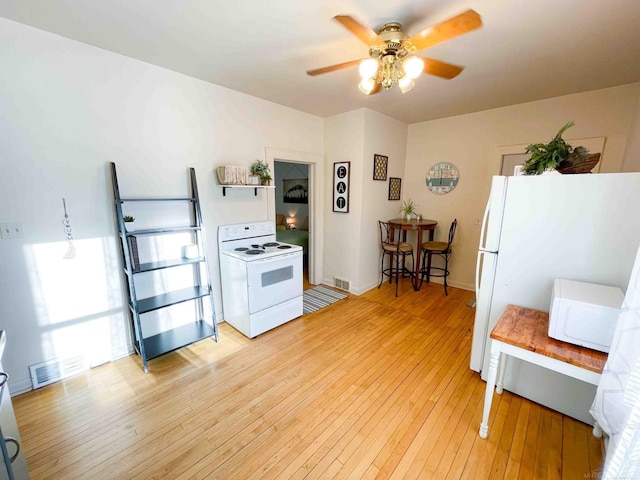 kitchen featuring visible vents, a ceiling fan, light wood-style flooring, and white appliances
