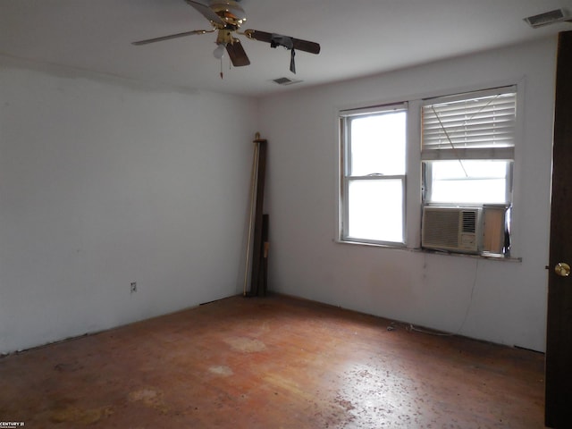 spare room featuring ceiling fan, visible vents, and cooling unit