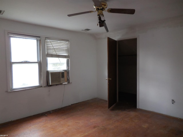 unfurnished bedroom featuring light wood-style floors, a ceiling fan, cooling unit, and visible vents