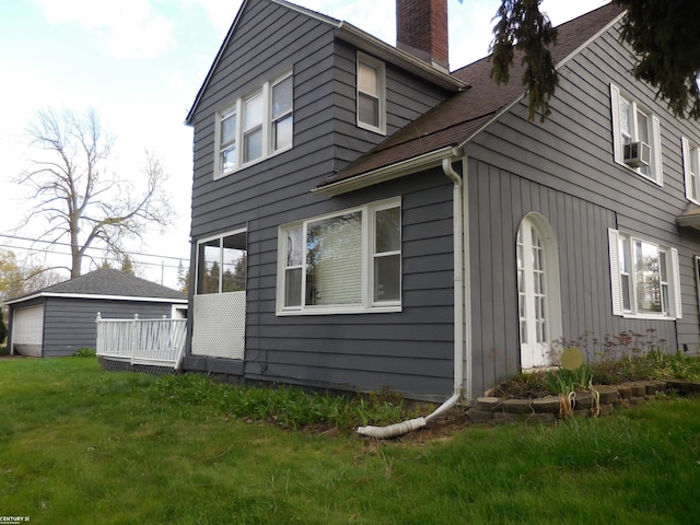 view of side of property with a shingled roof, a yard, a chimney, and cooling unit