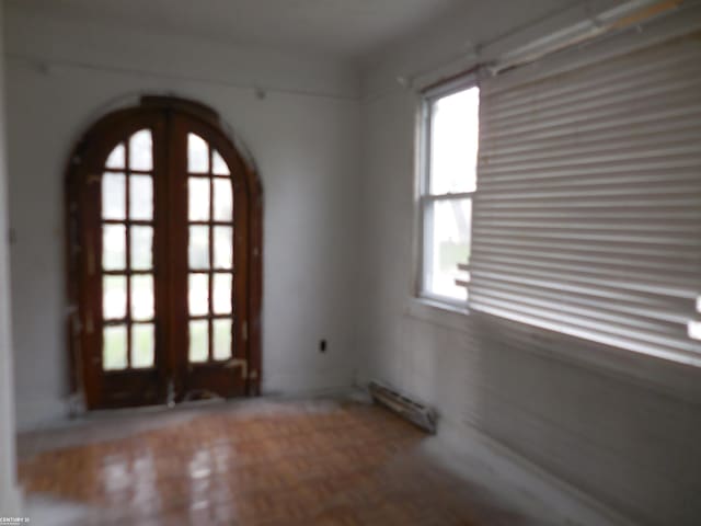 spare room featuring arched walkways and a wealth of natural light
