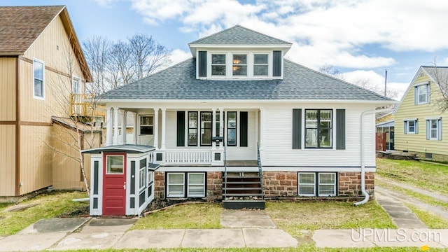 bungalow-style home featuring a porch, a shingled roof, and a front yard