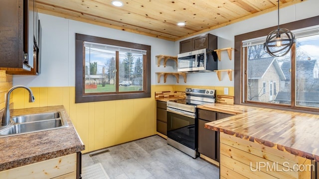 kitchen featuring a sink, stainless steel appliances, butcher block counters, and a healthy amount of sunlight