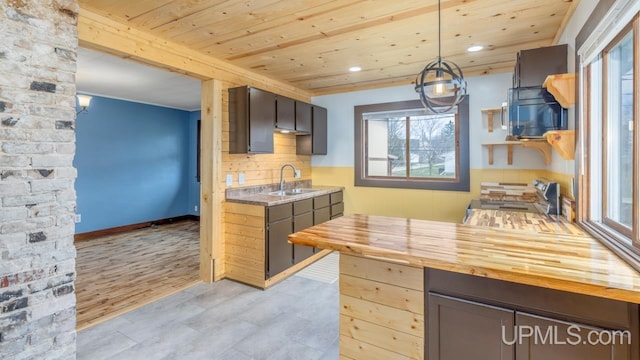 kitchen with stainless steel range, wooden ceiling, a sink, and plenty of natural light