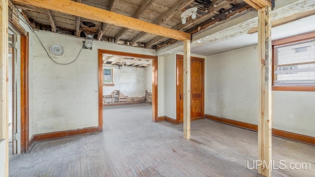 basement with baseboards and hardwood / wood-style floors