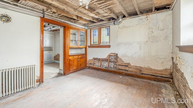 basement with radiator and light wood finished floors