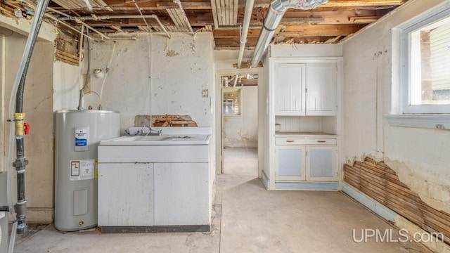 below grade area featuring a sink and electric water heater