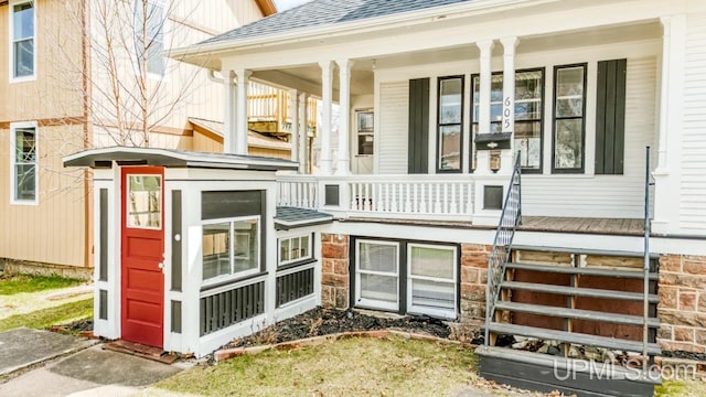 property entrance with a porch and a shingled roof