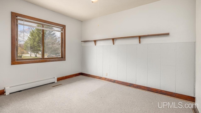 carpeted spare room featuring visible vents, a baseboard radiator, and baseboards