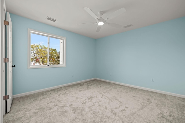 spare room with a ceiling fan, baseboards, visible vents, and carpet