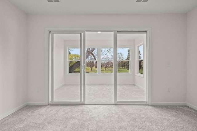 spare room with baseboards, carpet flooring, and visible vents