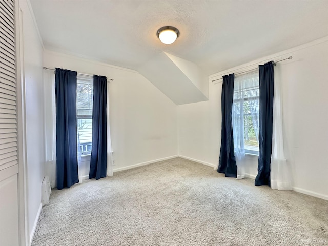 bonus room with vaulted ceiling, carpet floors, a baseboard heating unit, and a textured ceiling