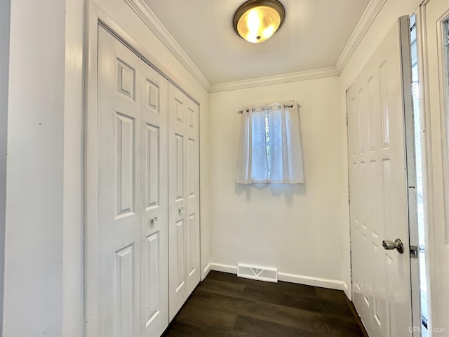 unfurnished bedroom featuring visible vents, baseboards, a closet, ornamental molding, and dark wood-type flooring