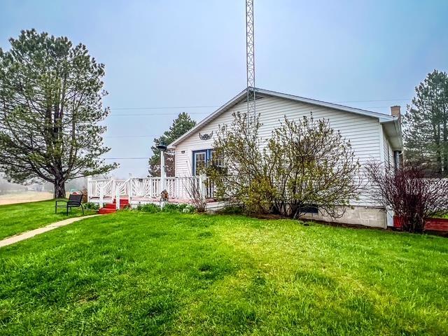 view of front of property with a wooden deck and a front lawn