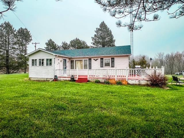 back of property featuring a lawn, a shingled roof, and a deck
