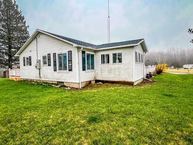rear view of property featuring a lawn