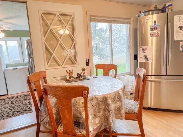 dining area with a ceiling fan and light wood finished floors