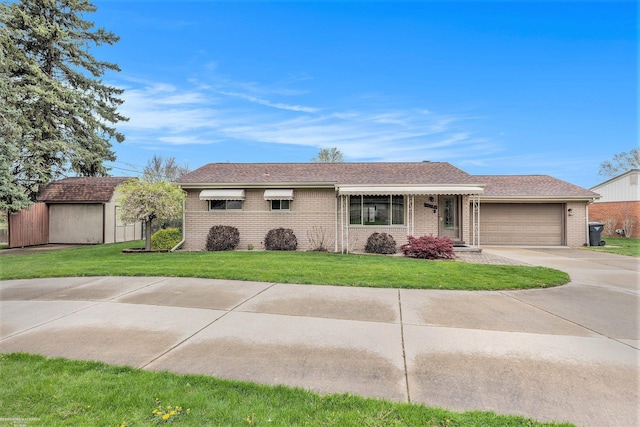 ranch-style house with a shingled roof, an attached garage, a front lawn, brick siding, and driveway