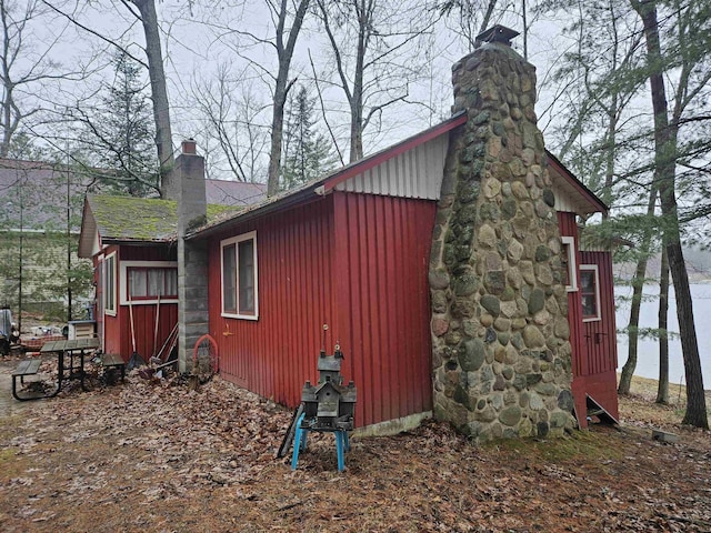view of home's exterior with board and batten siding and a chimney