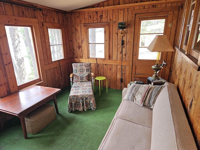carpeted living area with wood walls and lofted ceiling