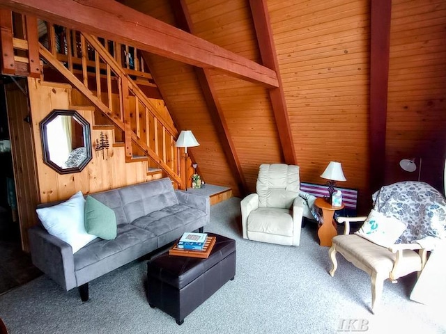 carpeted living room with vaulted ceiling with beams, wood walls, wooden ceiling, and stairway