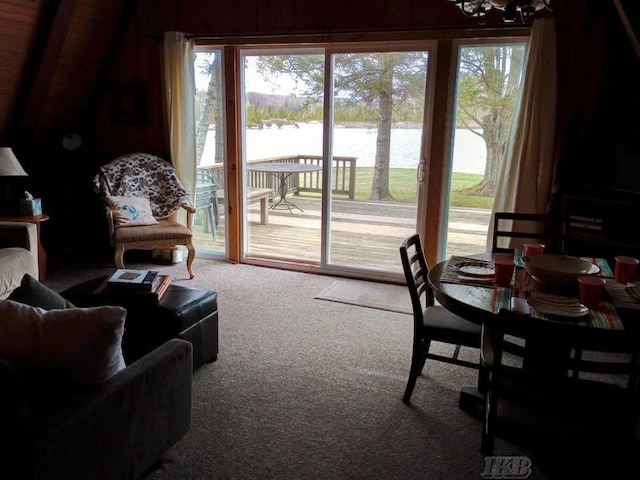 living area featuring carpet flooring, a water view, and an inviting chandelier