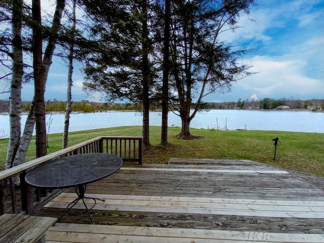 wooden deck featuring a lawn and a water view